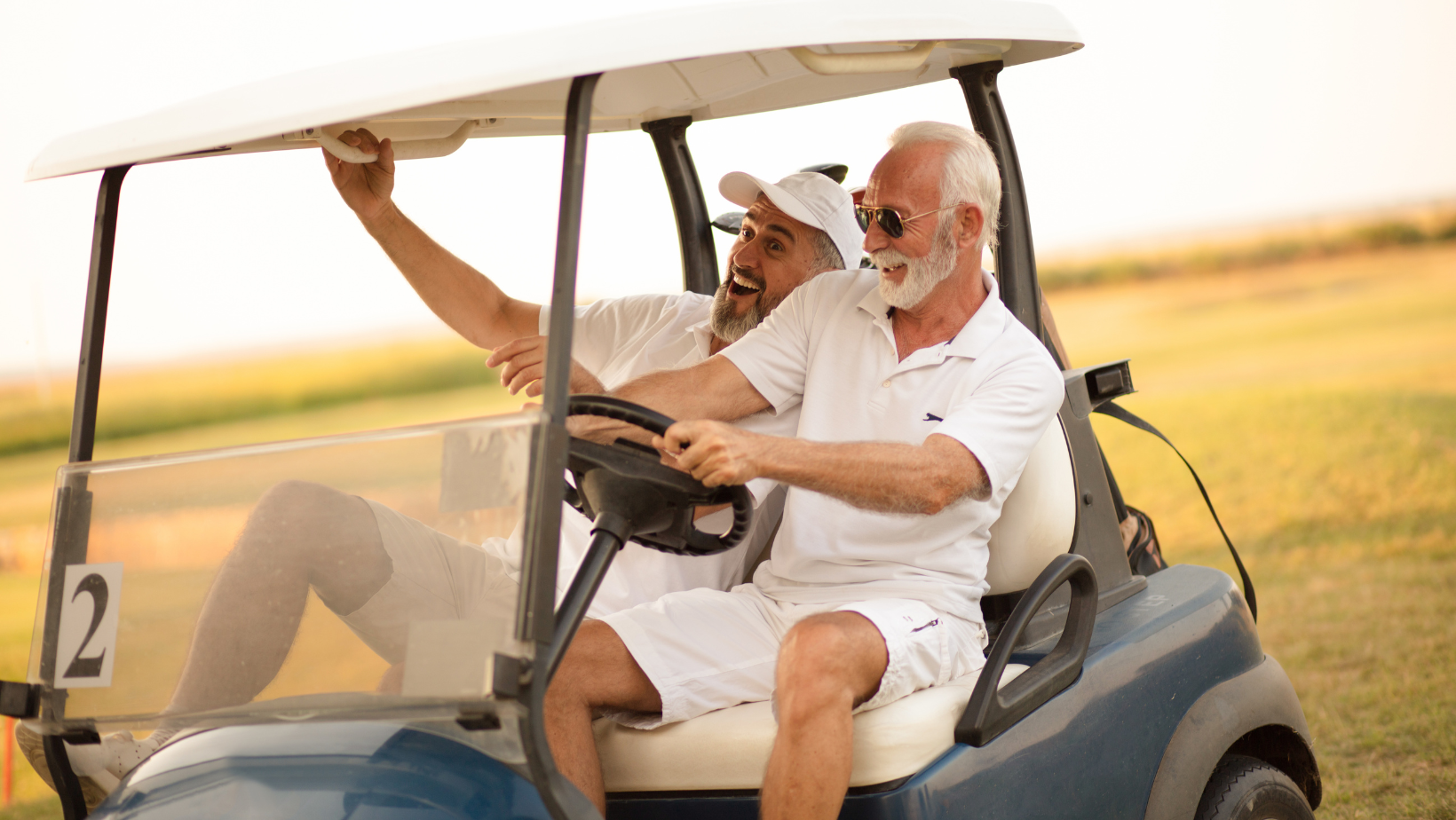 two older men in a golf cart